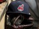 cleveland indians hat with chief wahoo logo laid atop a baseball mitt on the bench