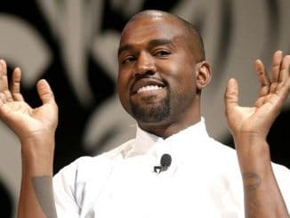 kanye west in a white shirt with his hands up