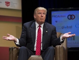 donald trump shrugging while sitting in a leather chair on stage
