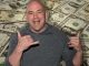 dana white smiling in front of a pile of dollar bills