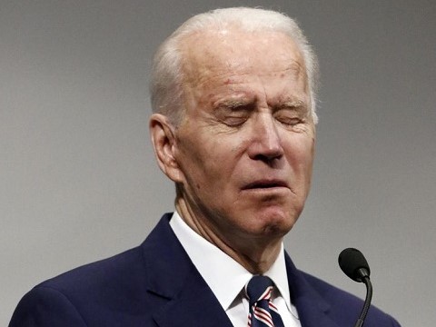 joe biden frowning with eyes closed at podium