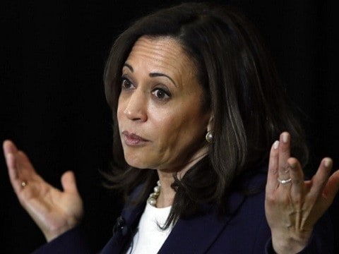 2020 democratic vp nominee kamala harris shrugs at the podium in from of a black background
