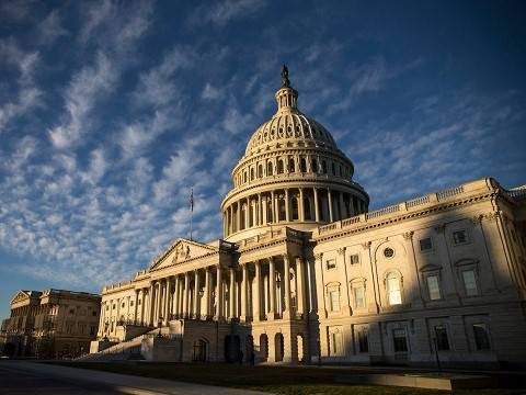 united states capitol building under a sunny sky with light clouds