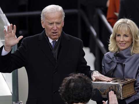 joe biden taking an oath with his hand on the bible