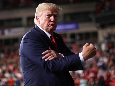 donald trump pumping his fist on stage at a rally